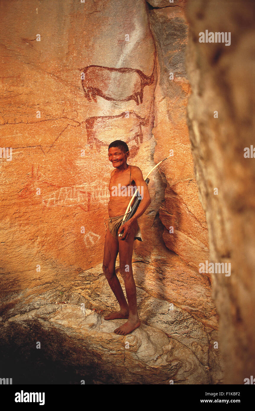 Bushman de pie delante de pinturas rupestres. Botswana, África Foto de stock