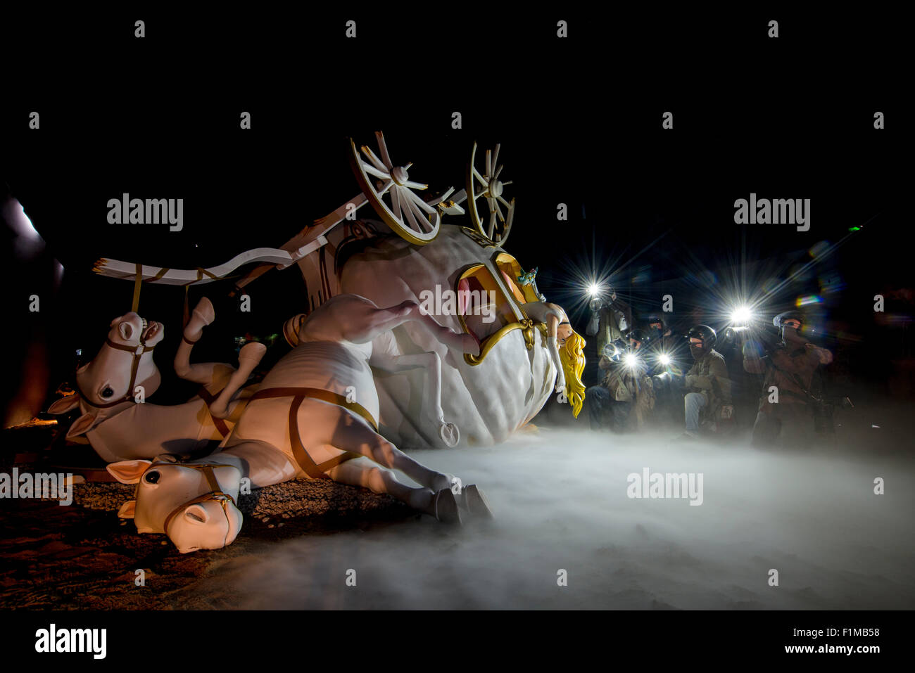 Banksy's Dismaland pedazo con una princesa muerta derramándose de un carro estrellado iluminado por las siguientes paparazzi. Foto de stock