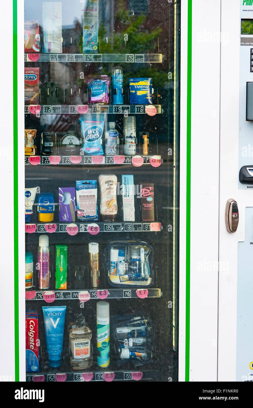 Máquina expendedora con artículos de tocador y artículos esenciales fuera de una farmacia Foto de stock