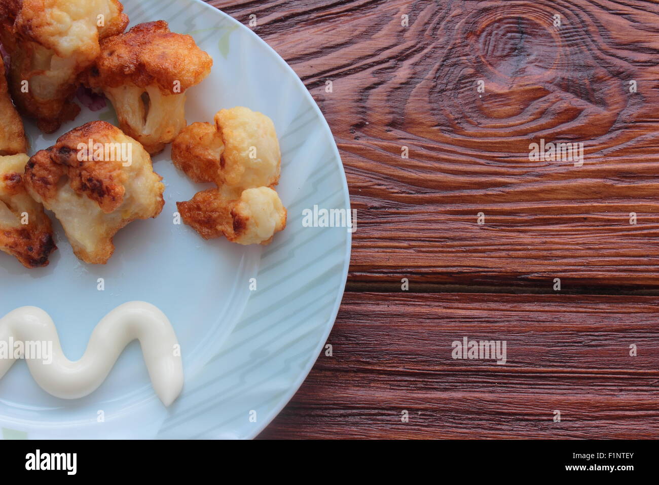 Acuéstese sobre una placa Coliflor frita y mayonesa Foto de stock