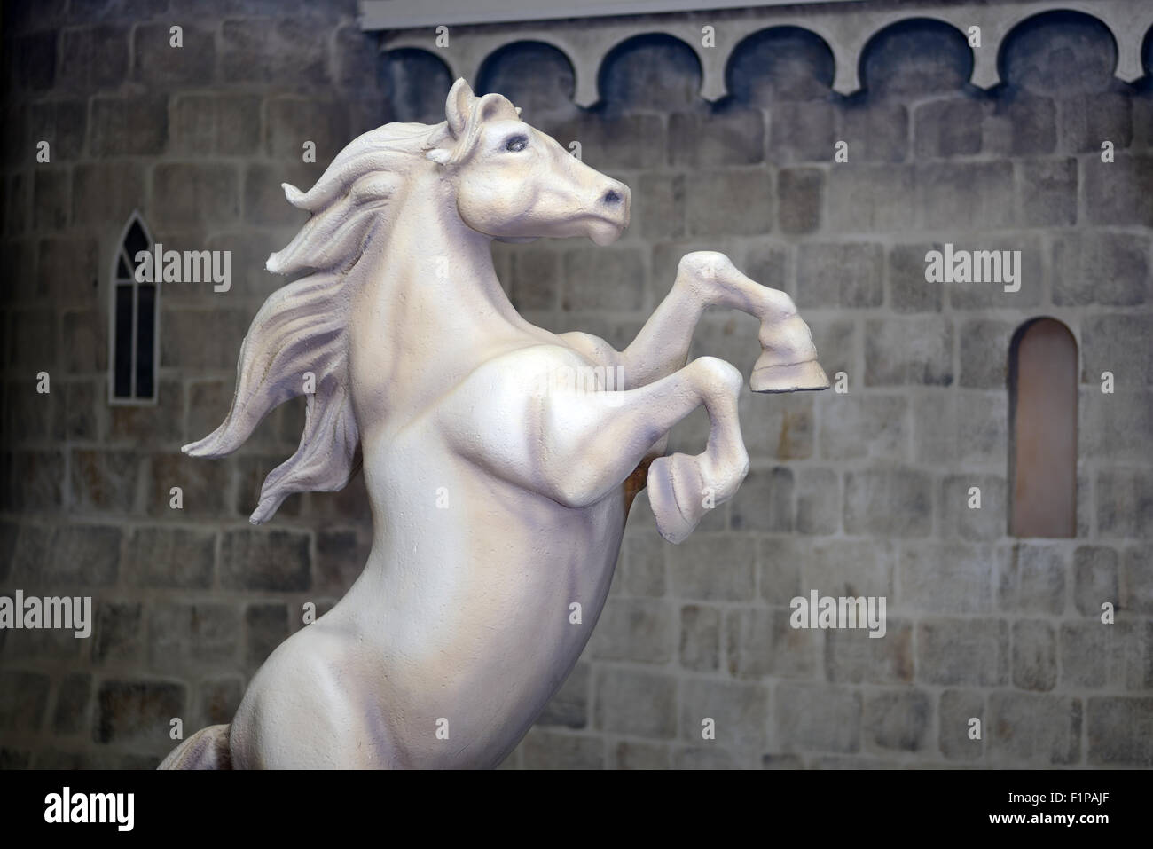 La estatua de un caballo de cría antes de una pared de castillo Foto de stock