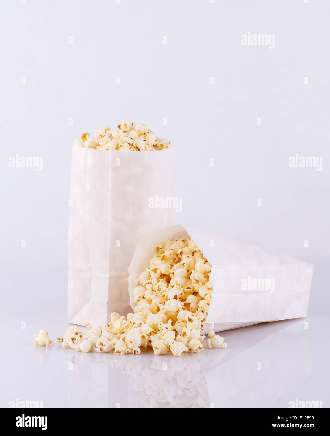 Palomitas de maíz en bolsas de papel extendido aislado sobre fondo blanco  Fotografía de stock - Alamy