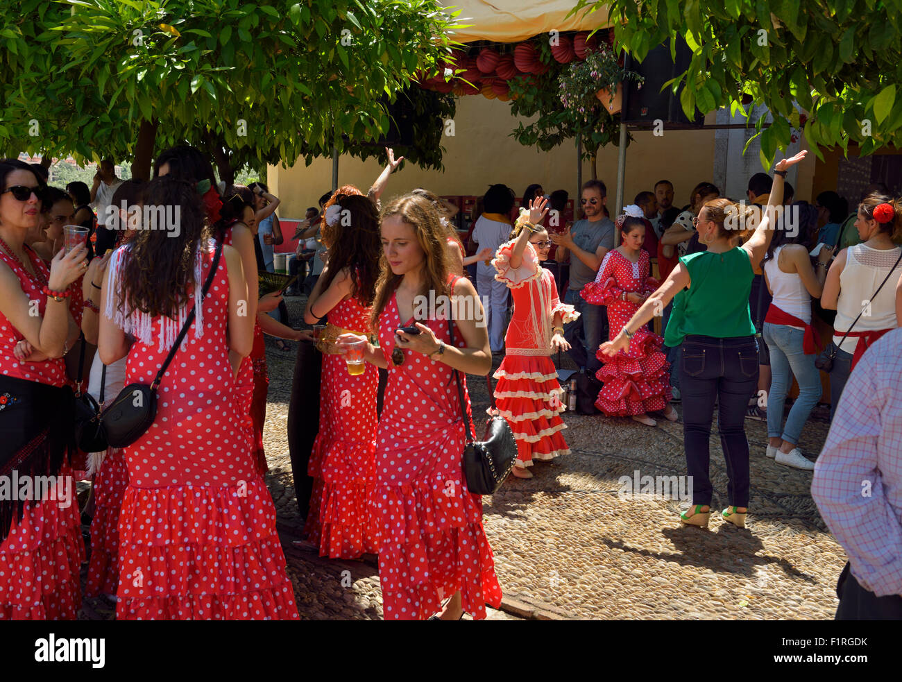 Cruces de mayo Festival con bailar sevillanas vestidos de lunares rojos y  bebiendo en casetas Fotografía de stock - Alamy