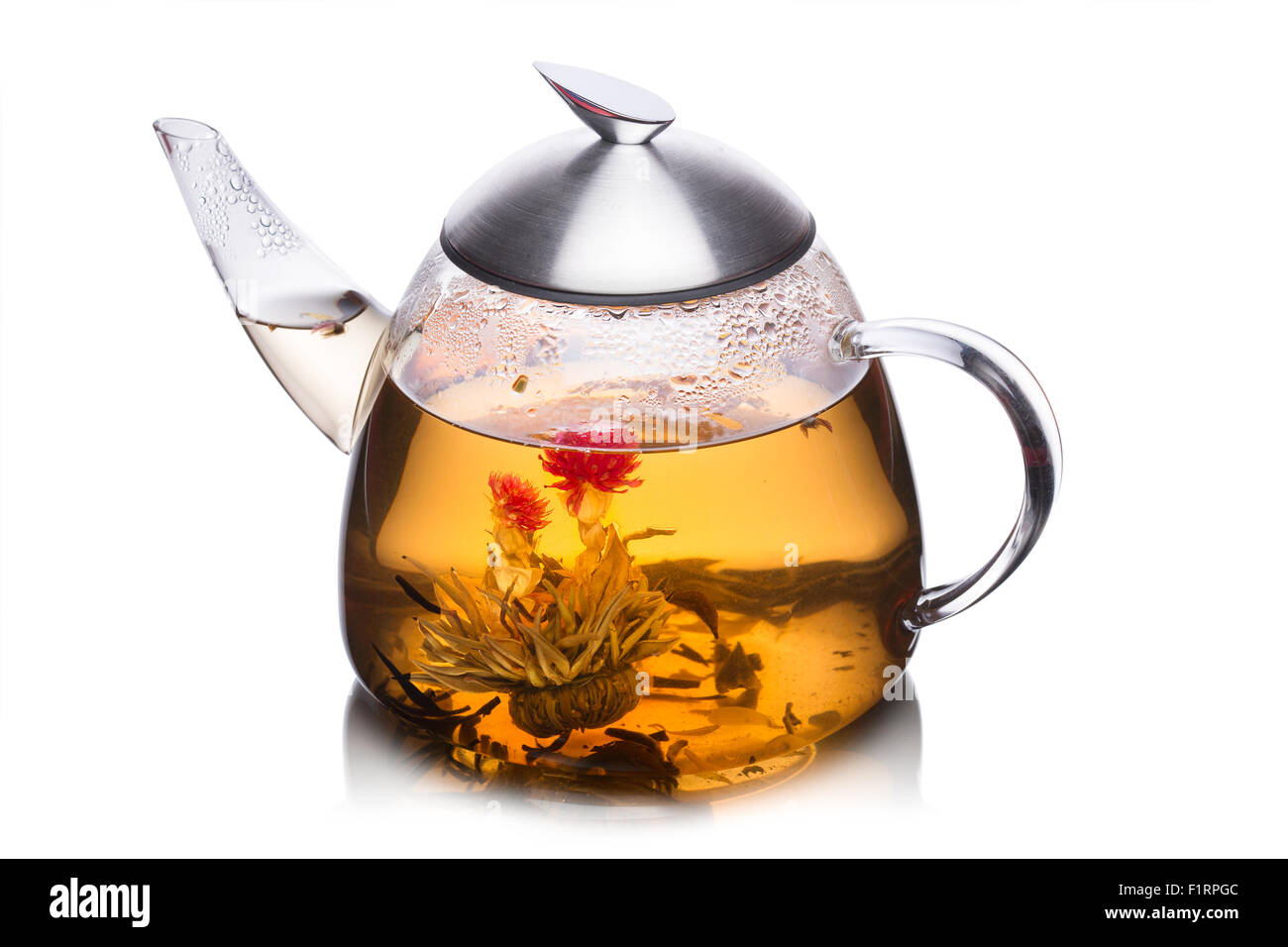 Vaso de agua lleno de té de hierbas con flores floreciendo. Comer sano. Sun tea Foto de stock