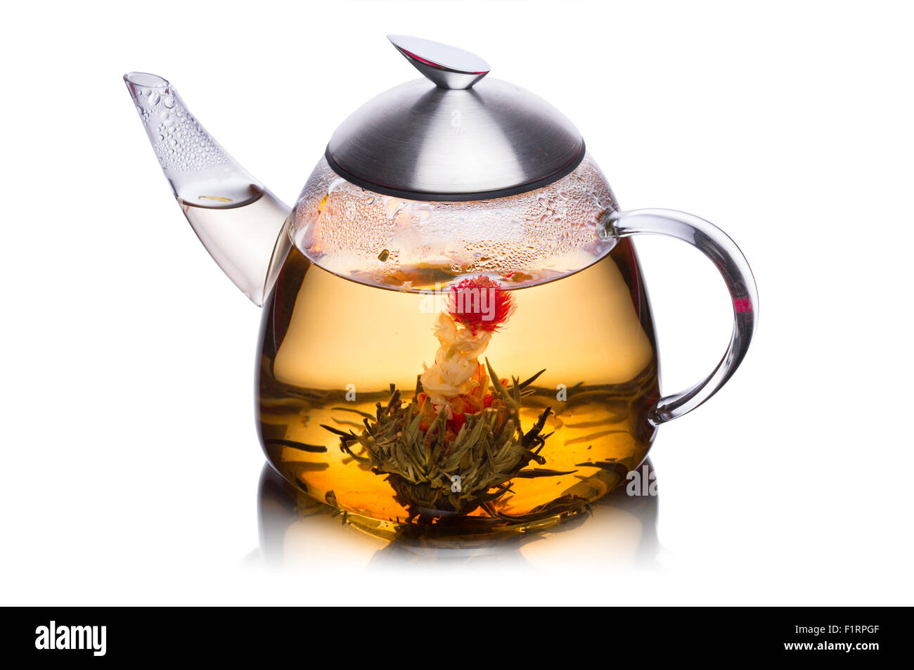 Vaso de agua lleno de té de hierbas con flores floreciendo. Comer sano. Sun tea Foto de stock