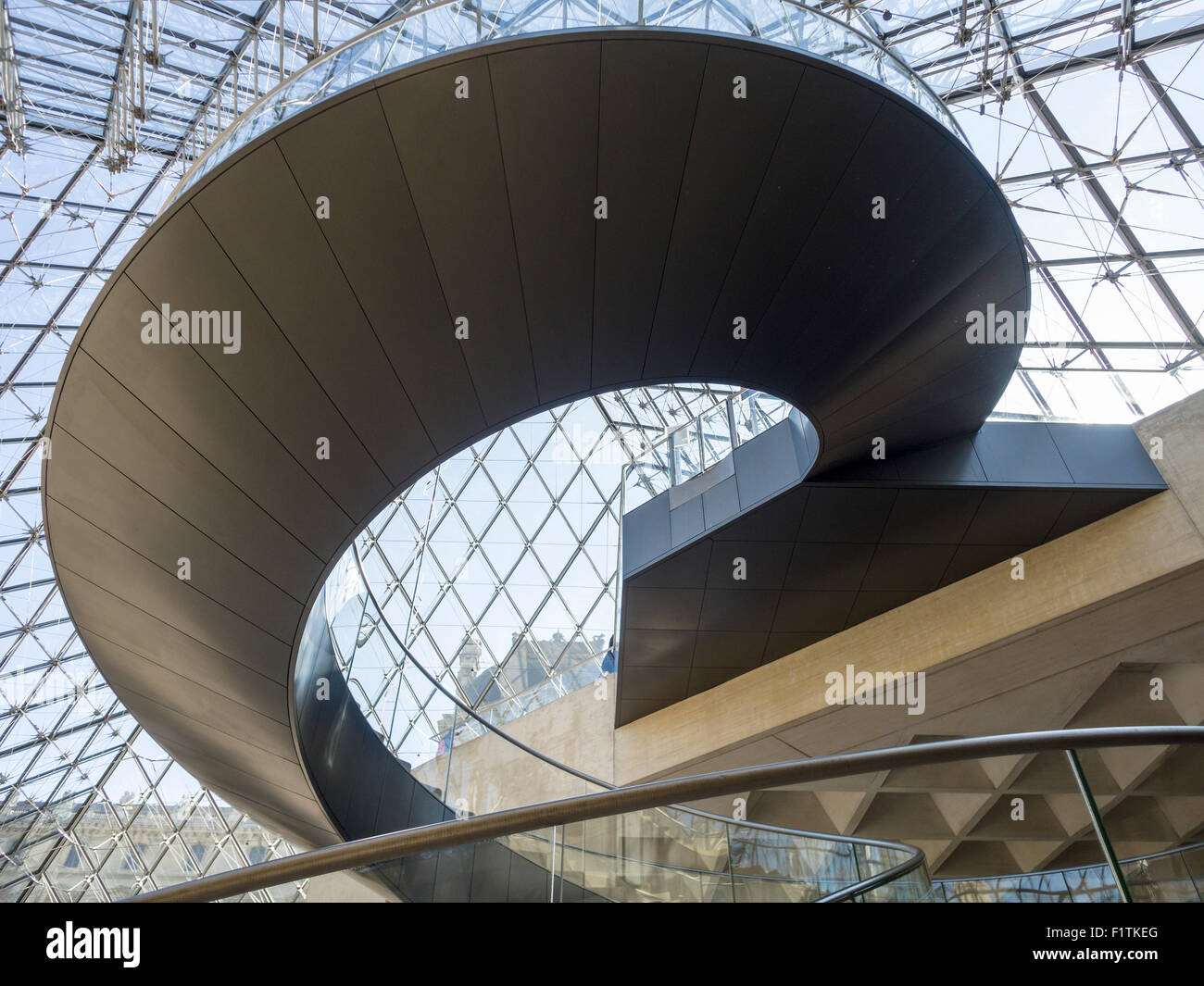 Louvre la moderna escalera curva bajo la pirámide. Esta escalera de caracol es parte de la pirámide principal entrada al museo Foto de stock