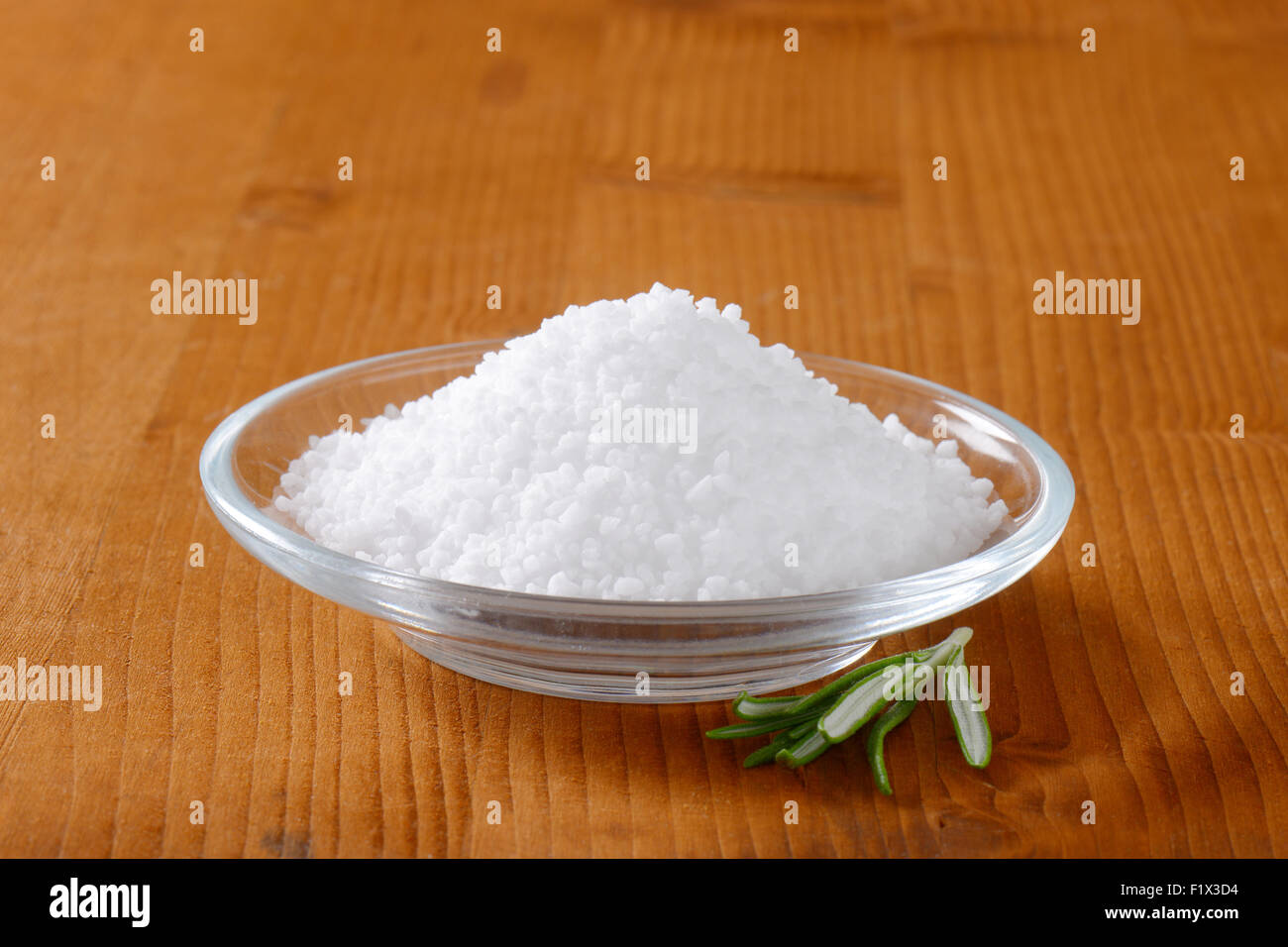 La sal comestible de grano grueso en la pequeña placa de vidrio Foto de stock