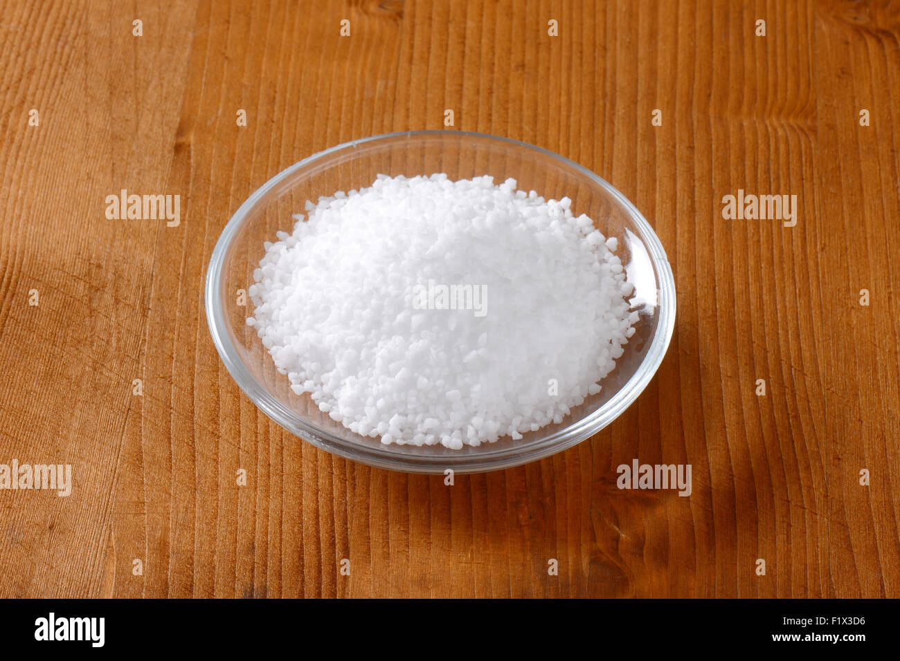La sal comestible de grano grueso en la pequeña placa de vidrio Foto de stock