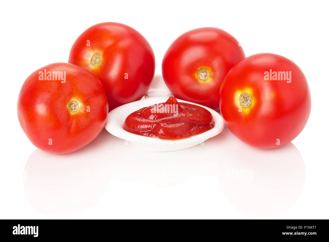 Recipiente con salsa de tomate y jugosos tomates rojos aislados en el fondo blanco. Foto de stock