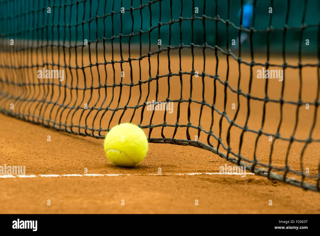 Amarillo pelota de tenis en una cancha de arcilla roja Foto de stock