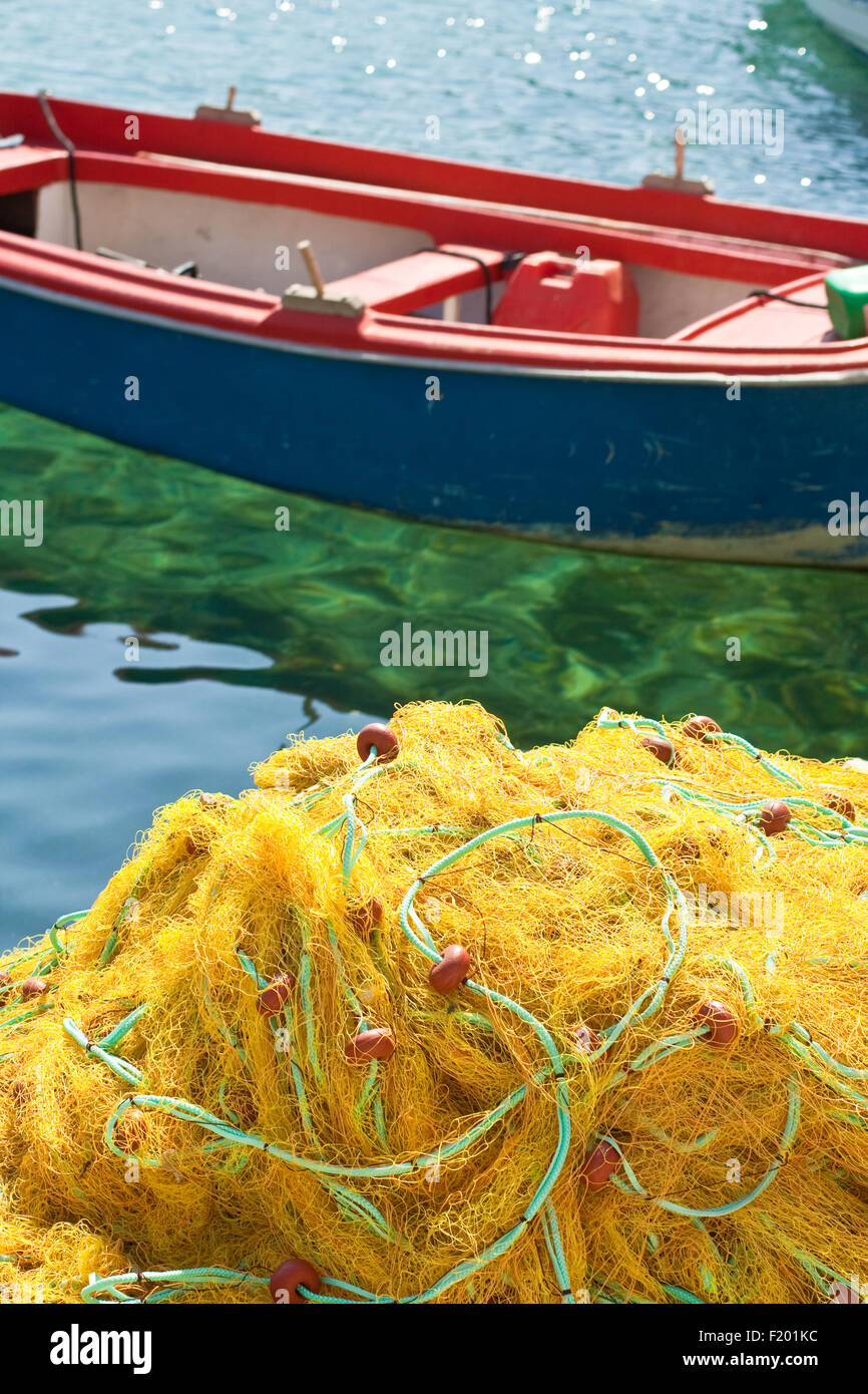 Las redes de pesca y el barco amarillo Foto de stock