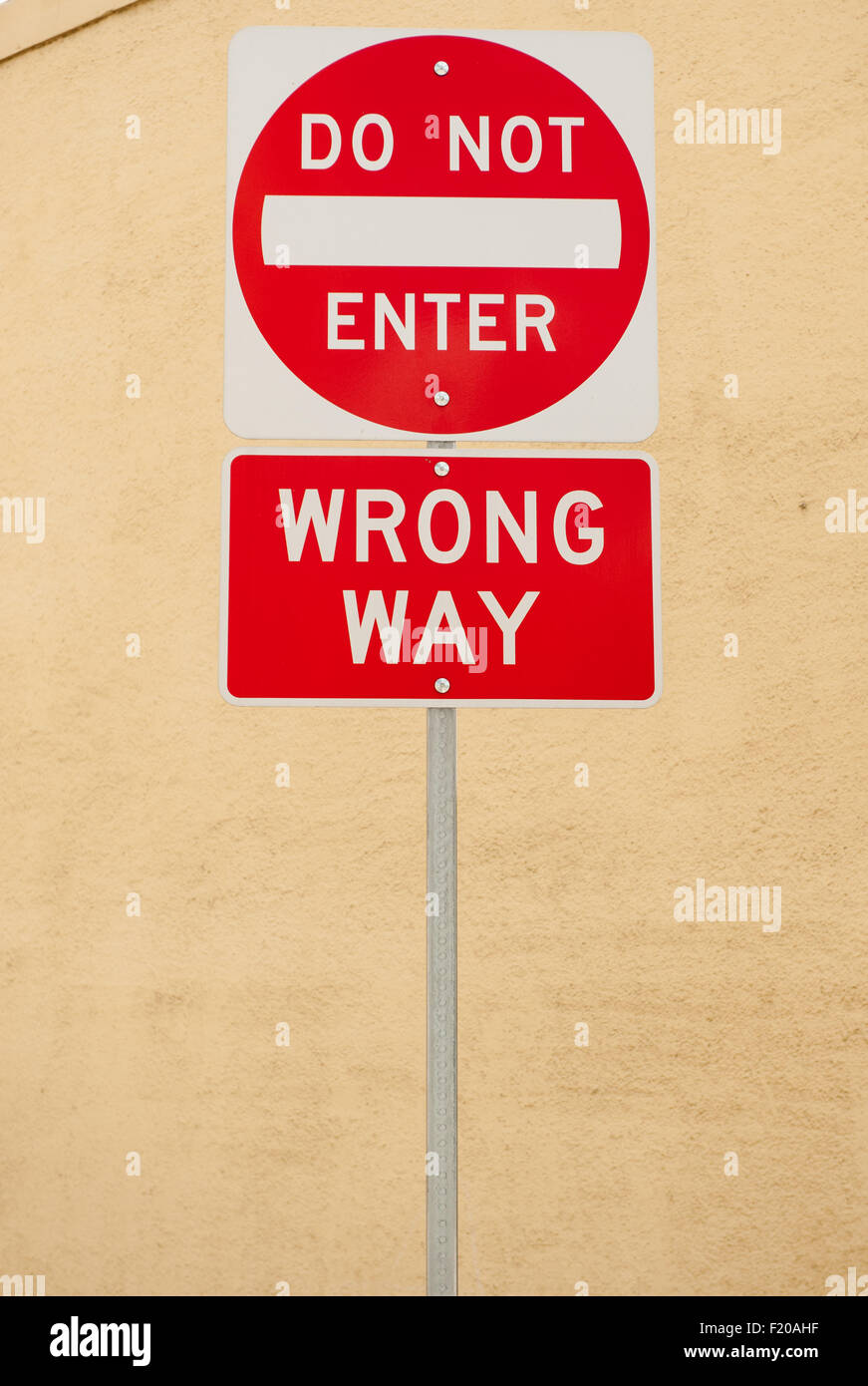 California, EE.UU. 'No Entrar' y 'camino equivocado' las señales de la carretera en escritura blanca sobre fondo rojo. Foto de stock