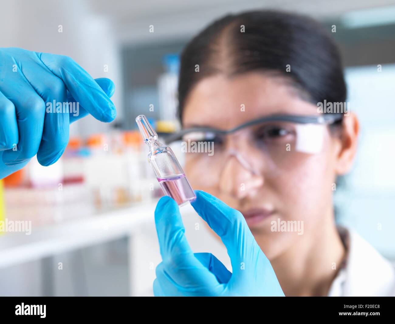 Investigadora probando drogas médicas ampolla en laboratorio Foto de stock