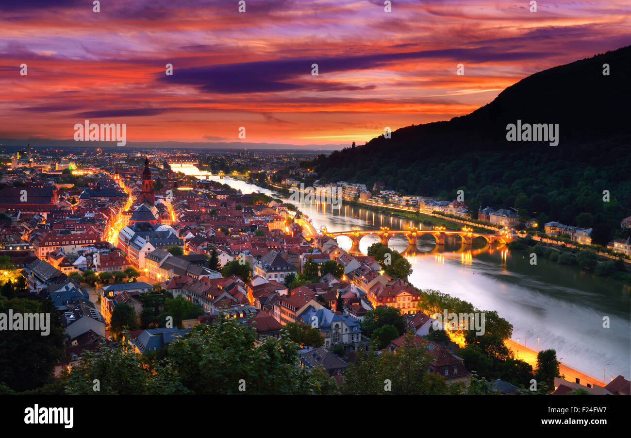 Heidelberg, Alemania, vista aérea al atardecer, con espectacular atardecer cielo y las luces de la ciudad, el río Neckar y el Puente Viejo Foto de stock