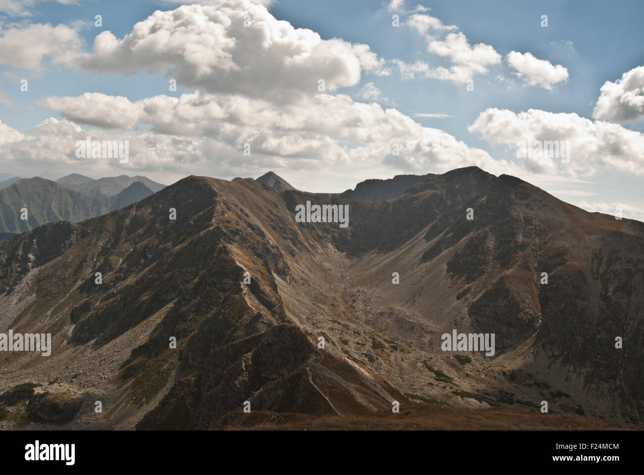 Valle en forma de u con picos alrededor y el cielo azul con nubes en parte de Tatra llamado Rohace Foto de stock