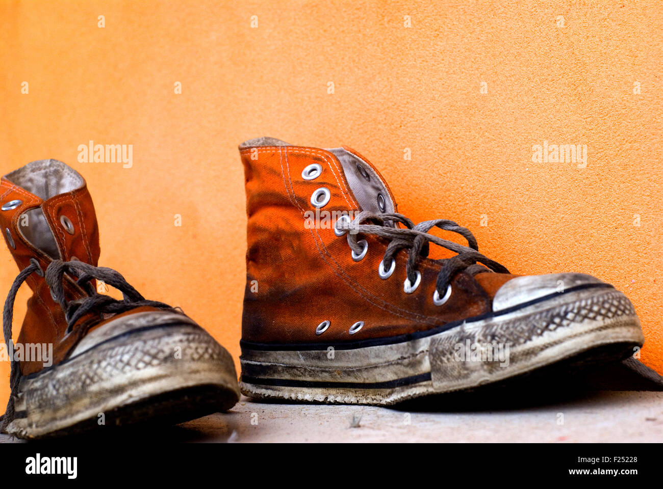 Viejas y sucias zapatos Converse All Star naranja sobre un fondo naranja de stock - Alamy
