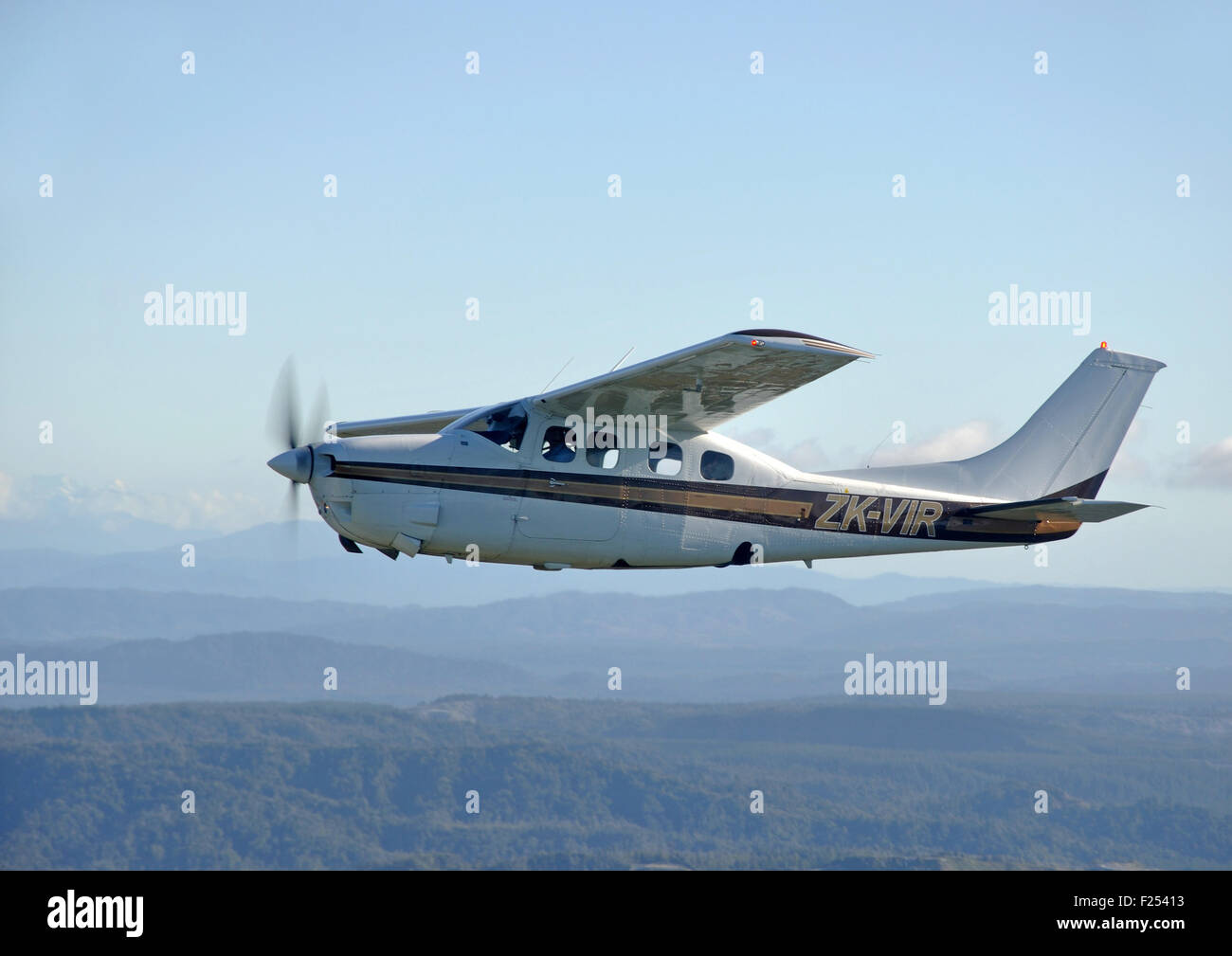Un presurizado Cessna 210 vuela por encima de la pintoresca costa oeste de Nueva Zelanda Foto de stock