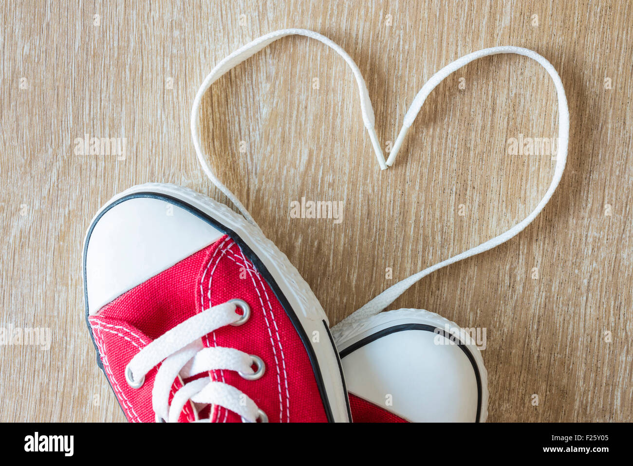 Con forma de corazón hecho con cordones de zapatillas rojas sobre un suelo  de parquet Fotografía de stock - Alamy