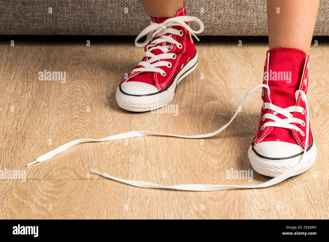 Niña vistiendo un par de zapatillas rojas en casa una zapatilla no condicionada Fotografía stock - Alamy