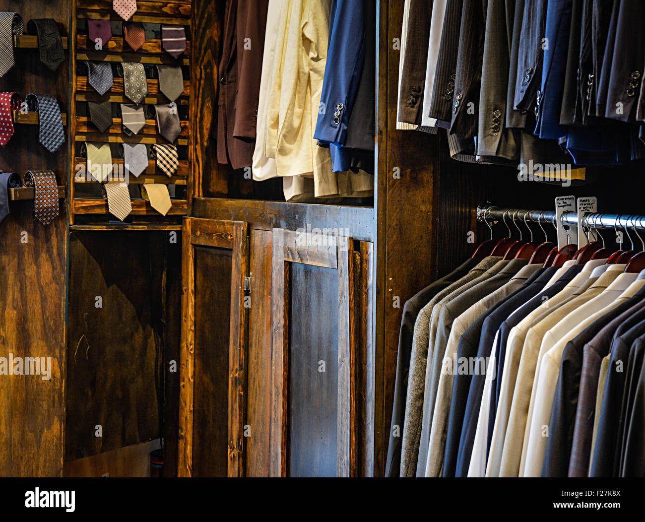 Preguntarse Detenerse ruptura Tienda de ropa personalizada de hombres muestra traje colgar abrigos,  chaquetas, corbatas y alteraciones en madera rústica muestra Fotografía de  stock - Alamy
