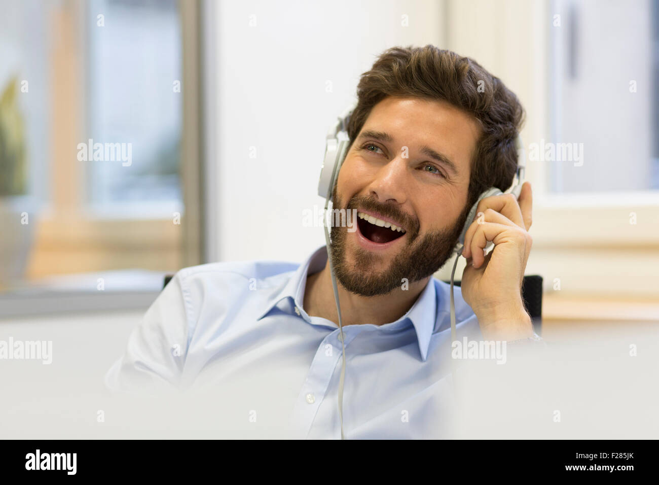 Cantando el empresario escuchar música con auriculares Foto de stock