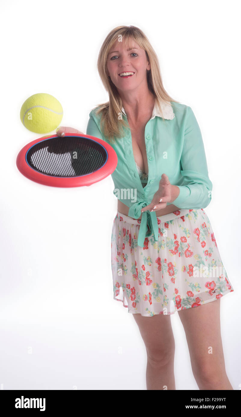 Mujer jugando un juego similar de tenis cubierto con un plástico redondo bat Foto de stock