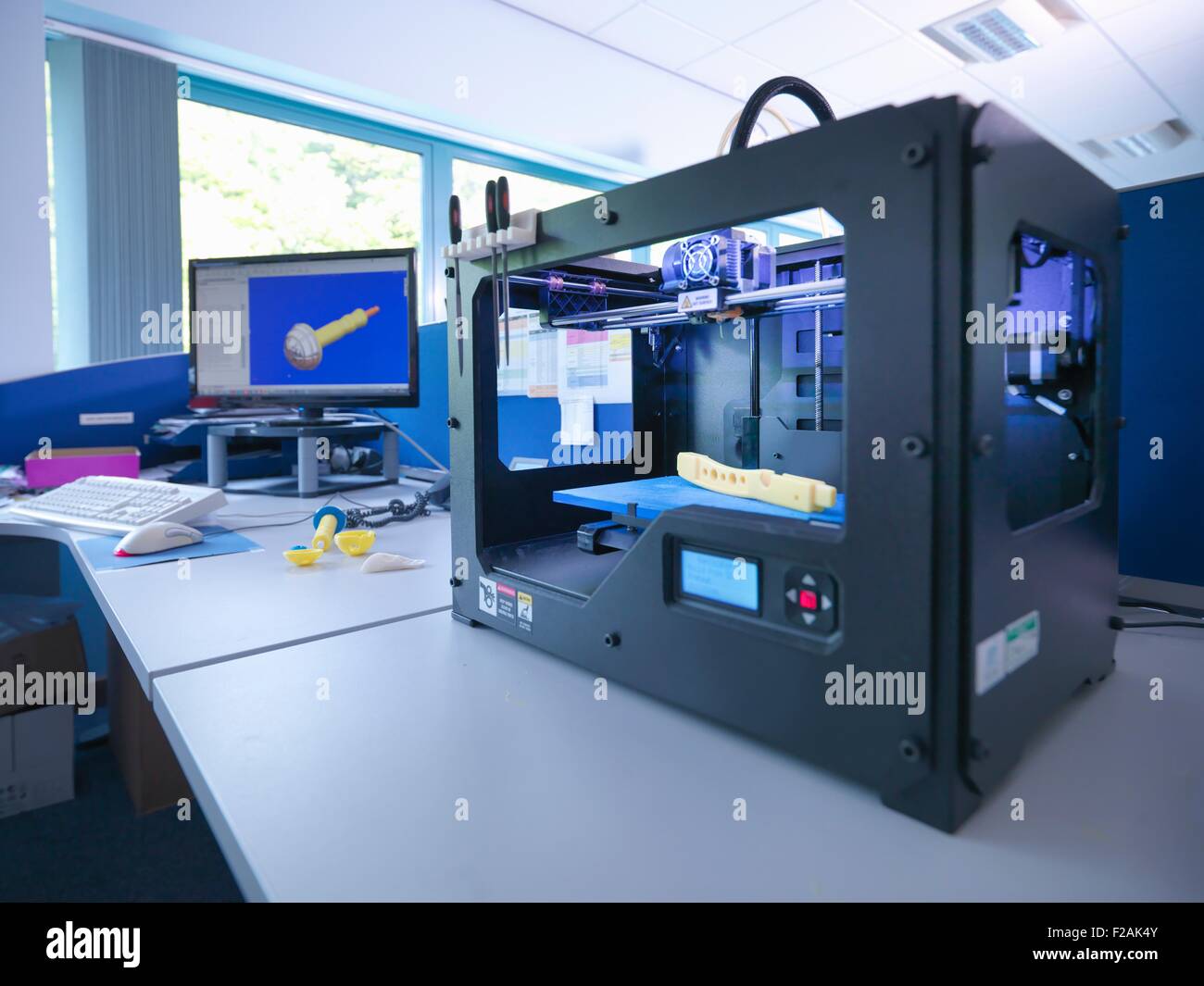 Con máquina de impresión 3D en la pantalla de diseño CAD en fábrica de ortopedia Foto de stock