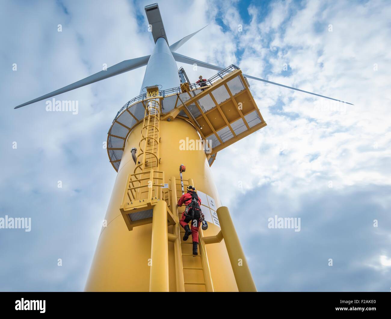 Ingenieros escalada aerogenerador desde barco en parques eólicos offshore, bajo ángulo de visión Foto de stock