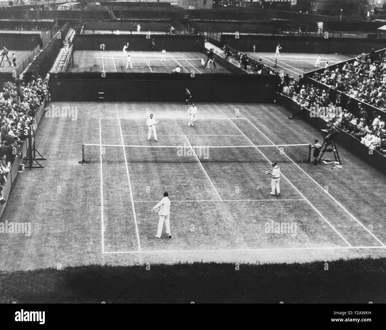 Inglés juego de campeonato de Tenis sobre Césped de Wimbledon, 2 de julio de 1930. En el tribunal más cercano, un doble partidos fue interpretado por Bill Tilden de EE.UU., y Hendrik Timmer de Holanda (derecha) en el primer plano y Roddell Deterding y, en el fondo. (CSU 2015 11 1324) Foto de stock