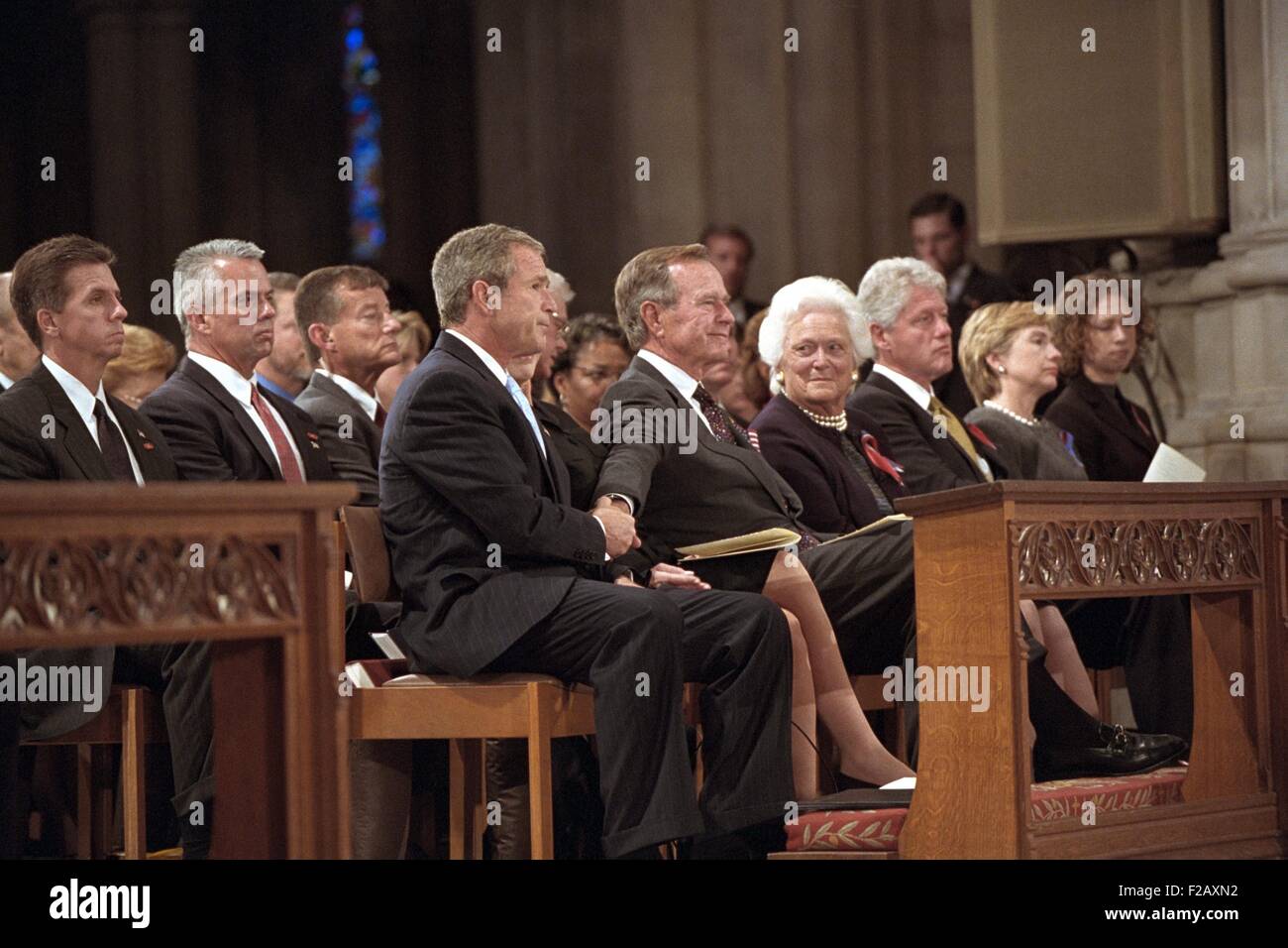 El presidente George W. Bush agarra la mano de su padre, el ex presidente George H. W. Bush. Asistían a la Jornada Nacional de Oración y Recuerdo el servicio para las víctimas de los ataques terroristas del 11 de septiembre. También en la primera fila, de izquierda a Bush 41, Sra. Barbara Bush, el ex presidente Bill Clinton, la senadora Hillary Rodham Clinton, Chelsea Clinton. Septiembre 14, 2001. (BSLOC 2015 2 150). Foto de stock
