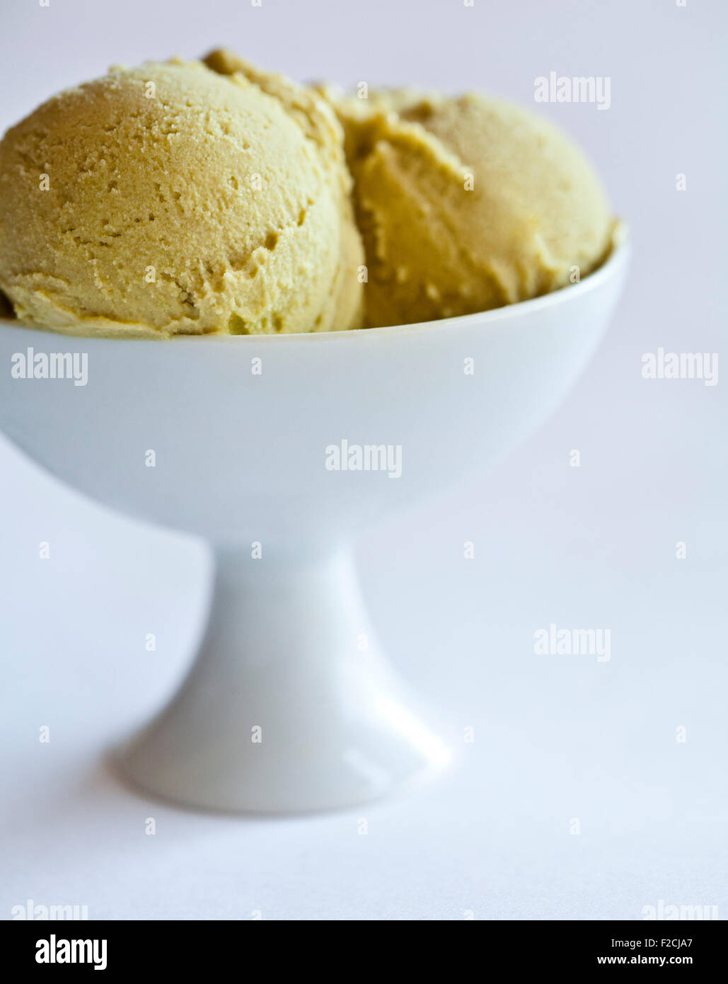 Dos bolas de sorbete de pistacho en blanco tazón de pedestal Foto de stock
