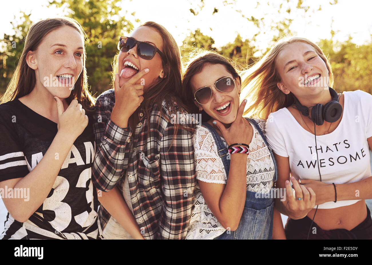 El grupo de niñas se burlan las expresiones a la cámara, fuera en un parque Foto de stock