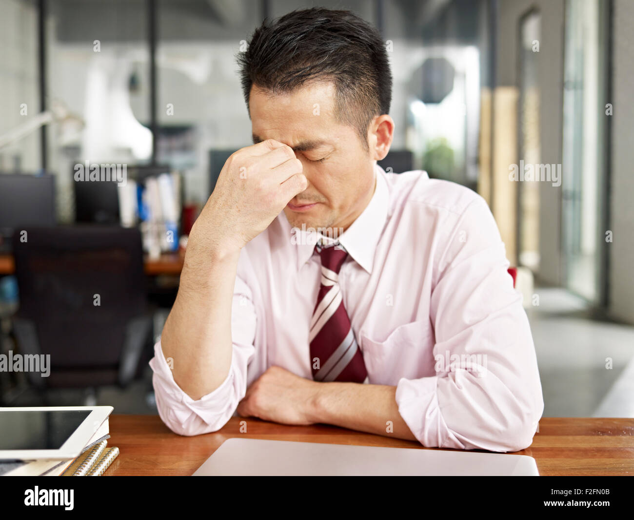 Empresario asiático aspecto cansado y frustrado Foto de stock