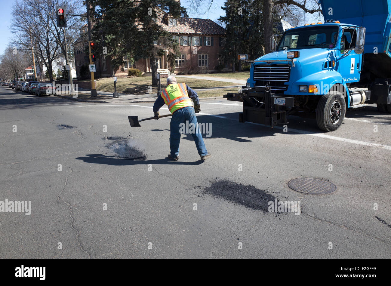 Trabajador agregando el asfalto para baches en las calles de la ciudad. St  Paul MN Minnesota EE.UU Fotografía de stock - Alamy