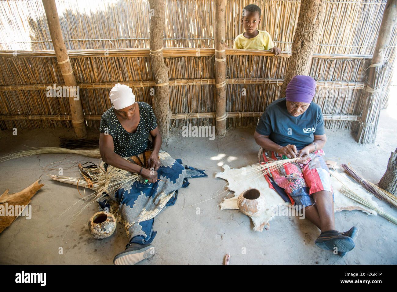Las mujeres en la aldea Sexaxa haciendo cuencos artesanales en Botswana, África Foto de stock