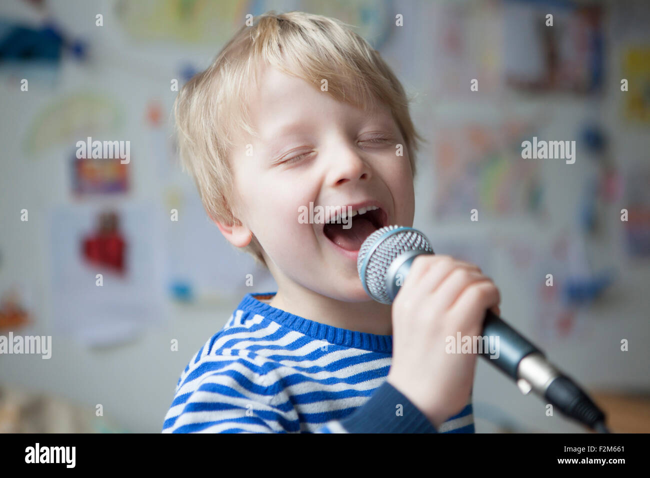 Retrato de niño cantando con micrófono Foto de stock