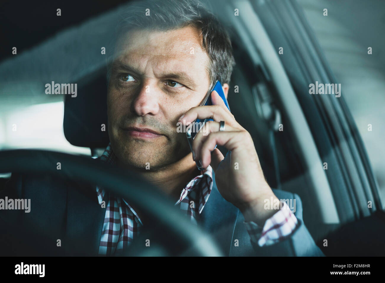 Empresario maduros usando smart phone en el coche Foto de stock