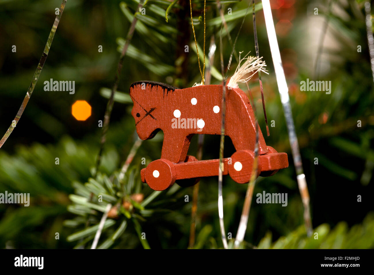 Cerca de un pequeño caballo con ruedas de madera de estilo de decoración del árbol de navidad Foto de stock