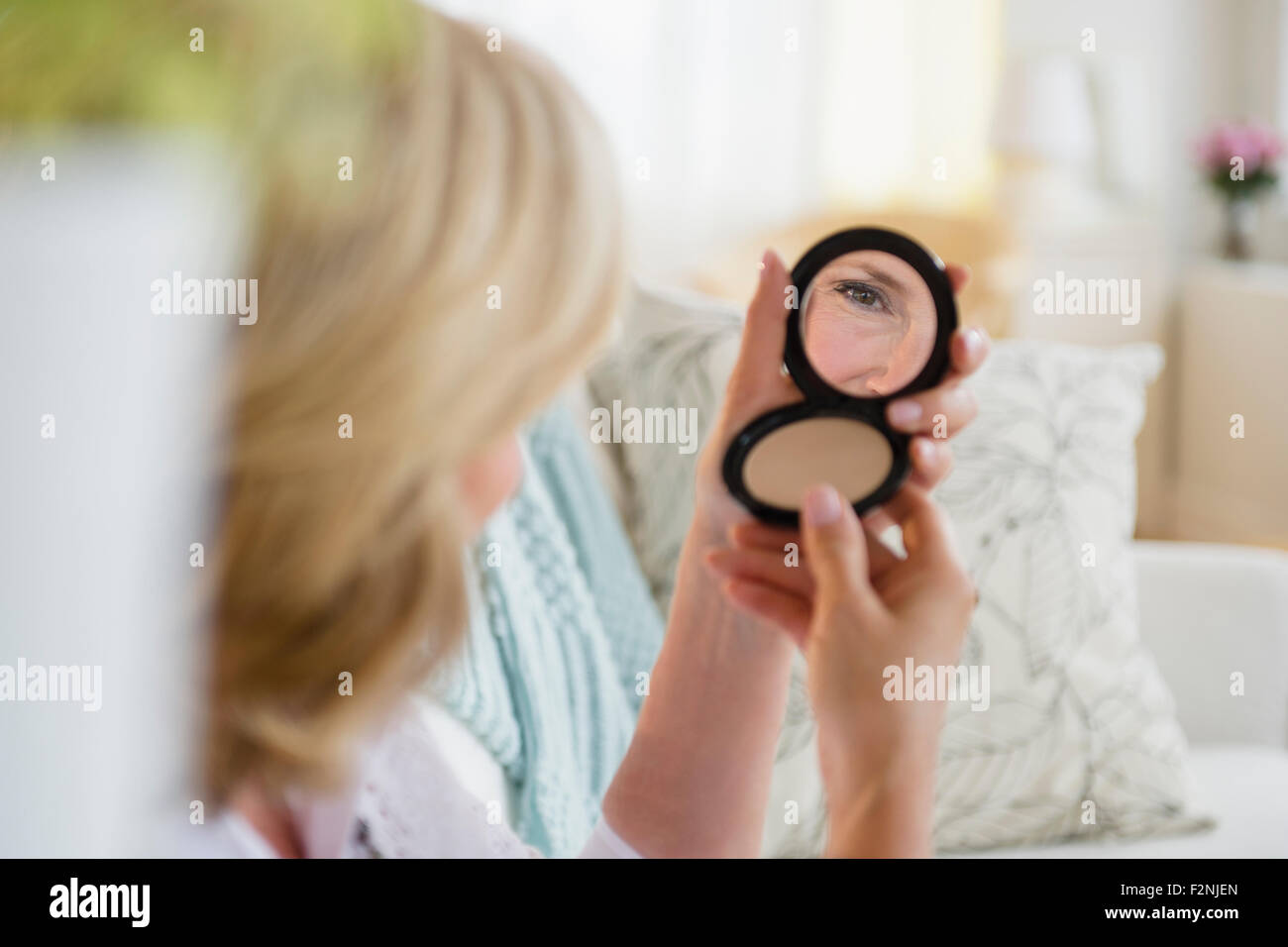 Mujer caucásica admira a sí misma en el espejo Foto de stock