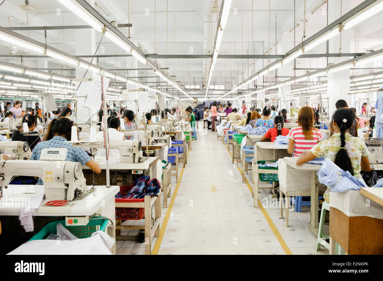 Trabajador Asiático cosiendo ropa en fábrica de prendas de vestir Foto de stock