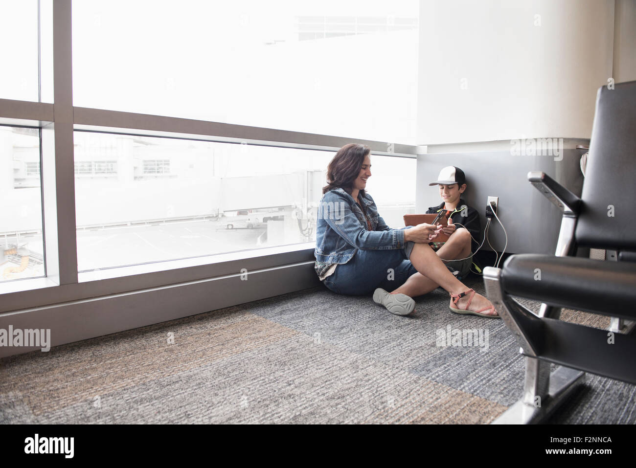 Madre e hijo mediante tableta digital en el aeropuerto Foto de stock