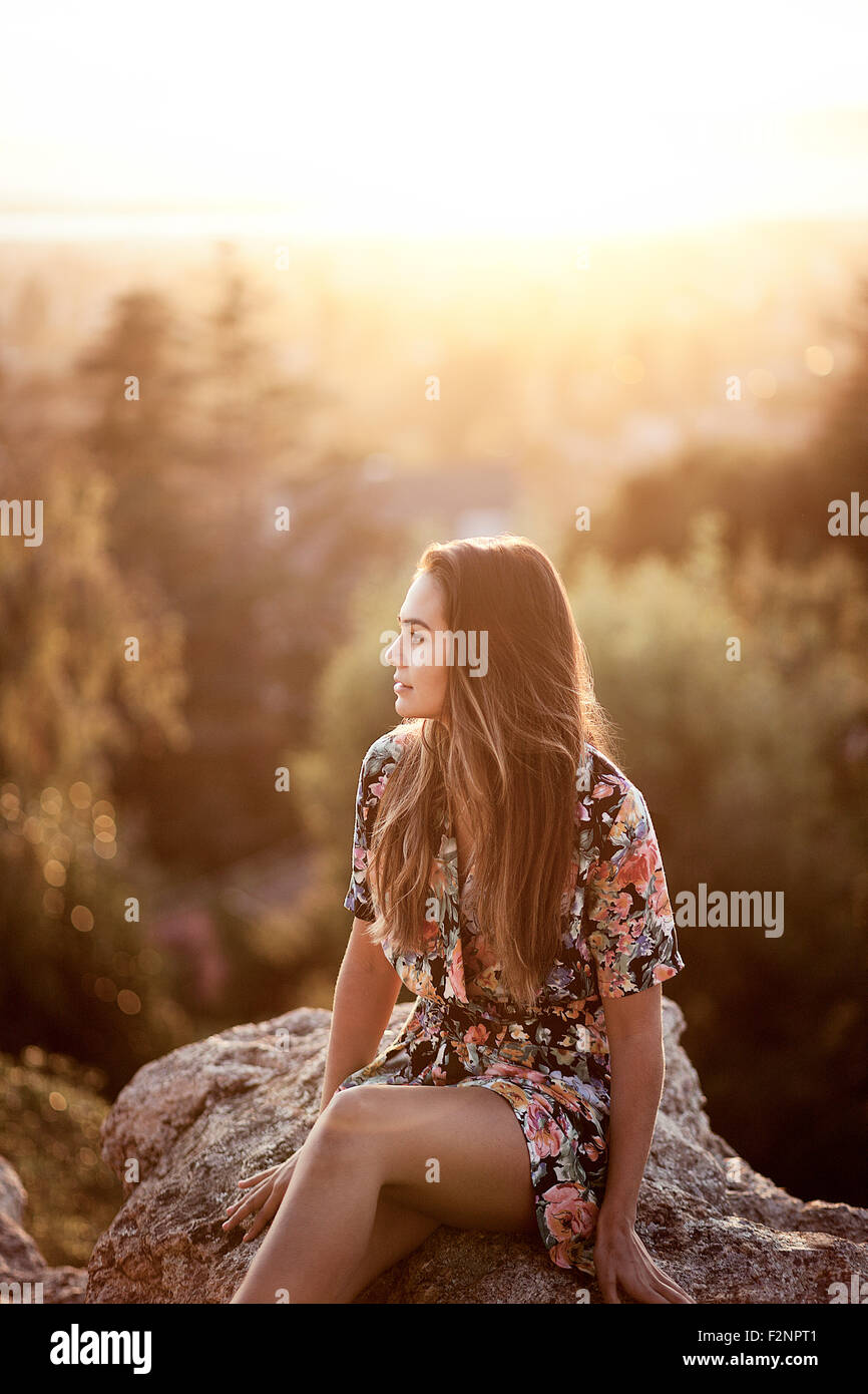 Raza mixta mujer sentada sobre boulder Foto de stock