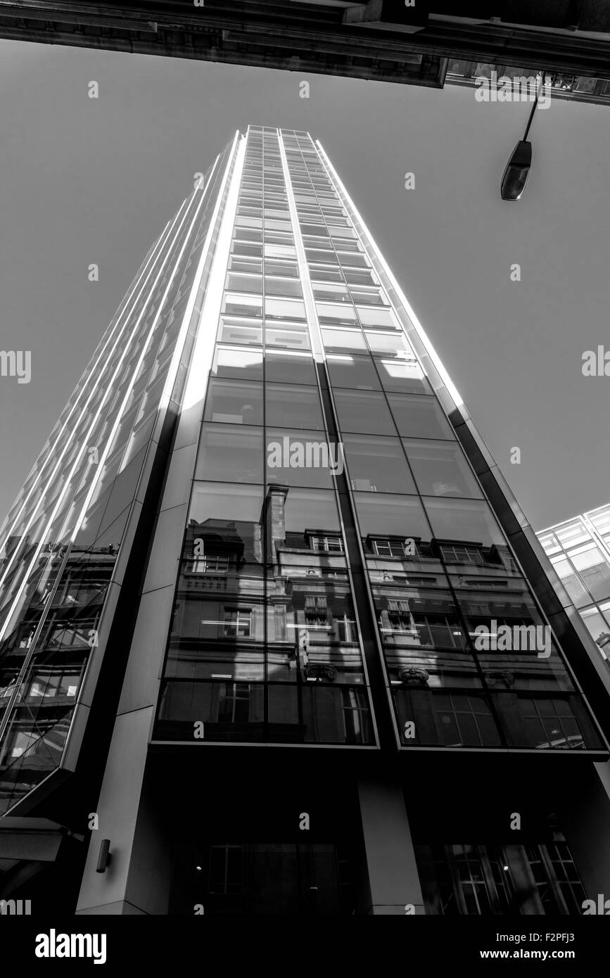 Mirando hacia la parte superior de un bloque de oficinas en Bishopsgate con un cielo claro y los reflejos en el cristal Foto de stock
