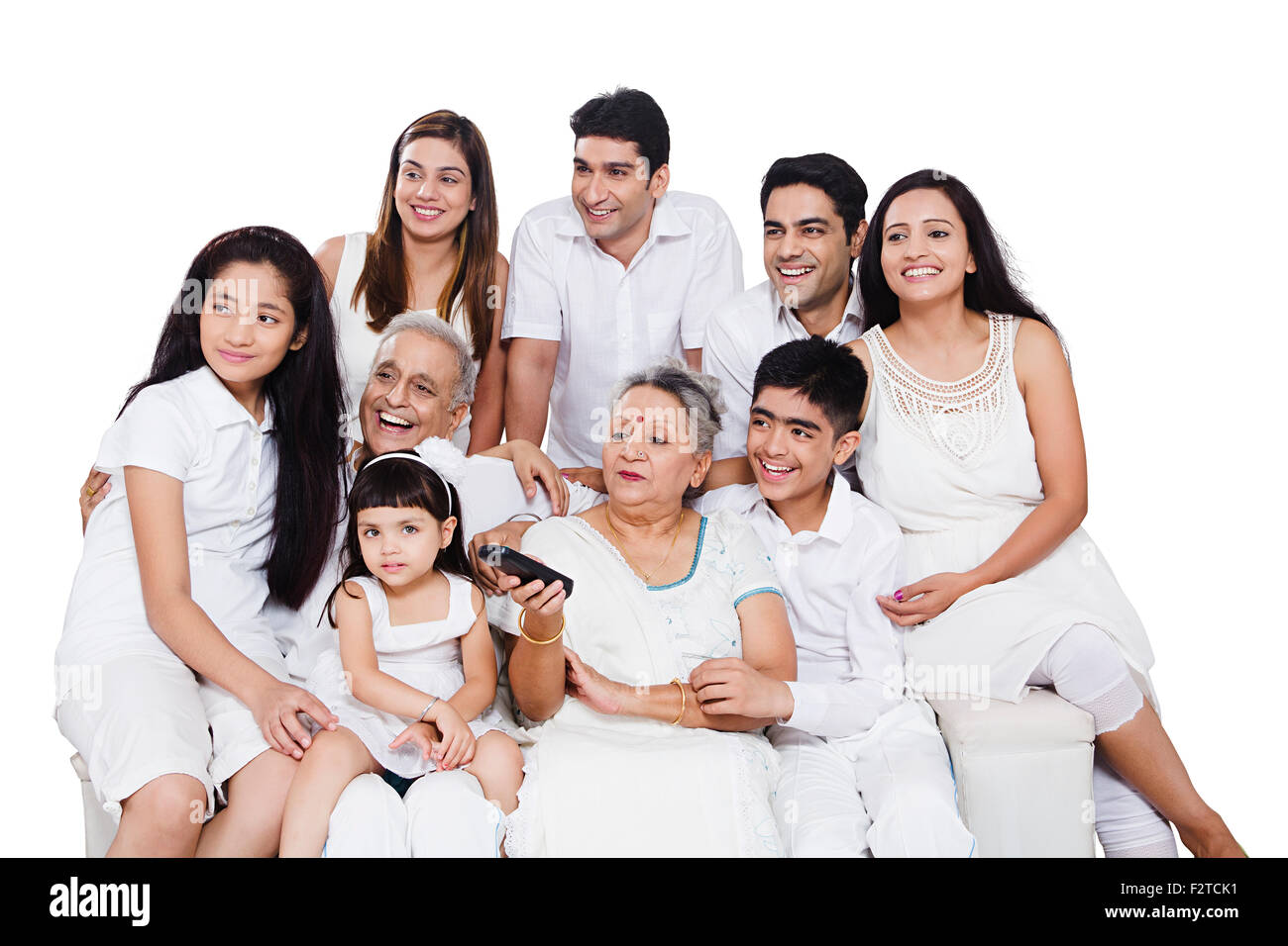 Familia conjunta del grupo indio sentado en el sofá mirando televisión