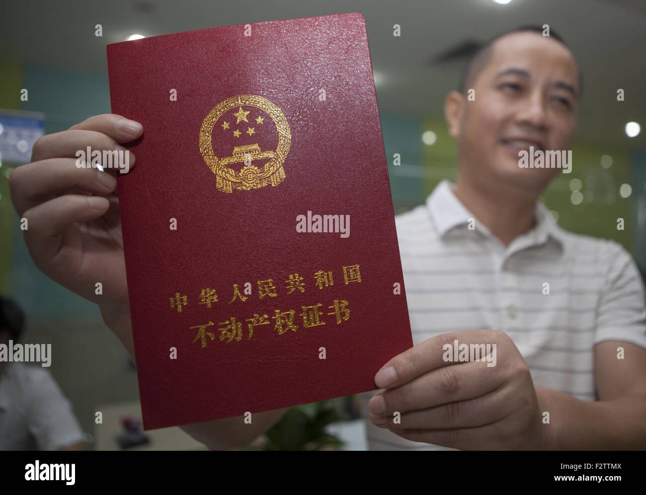 (150924) -- SHENZHEN, el 24 de septiembre, 2015 (Xinhua) -- residente apellidado Zhu muestra su certificado inmobiliario en una administración responsable para el registro de la propiedad unificada en Shenzhen, en el sur de la Provincia china de Guangdong, el 22 de septiembre, 2015. China Southern boomtown Shenzhen comenzaron el martes su propiedad unificada de registro como parte de una inserción nacional para regular el mercado inmobiliario. El Consejo de Estado, el Gabinete de China, publicó el reglamento de registro de la propiedad en diciembre de 2014, los analistas dicen que arrojará luz sobre los funcionarios corruptos" activos ilícitos, proteger la propiedad y haga factible Foto de stock