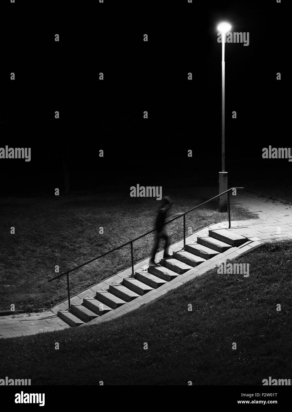 Una escena nocturna. Figura Humana en motion blur subir escaleras. Foto de stock