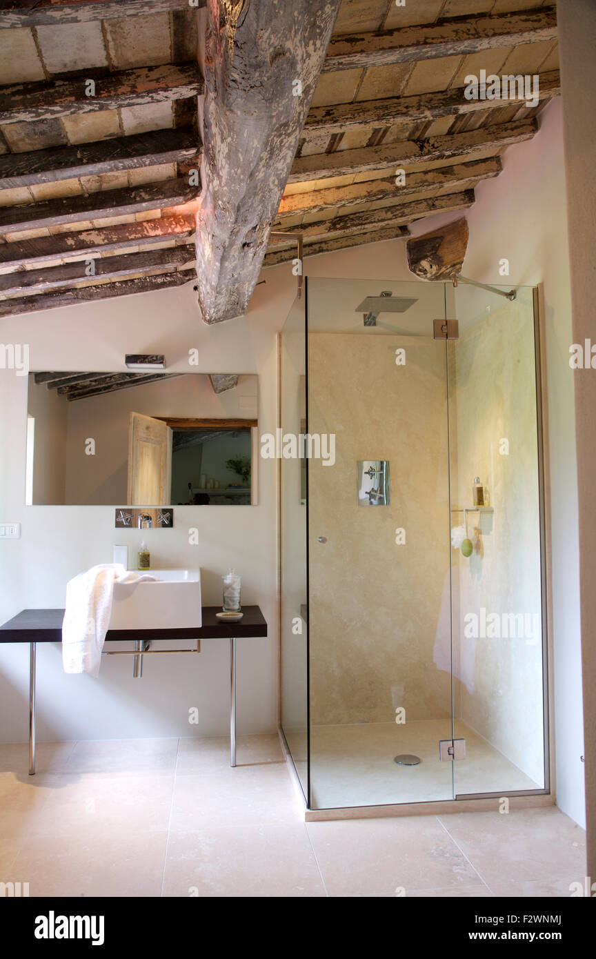 Vidrio moderna ducha, armario y lavabo en italiano país Baño con techo de  vigas de madera rústica Fotografía de stock - Alamy