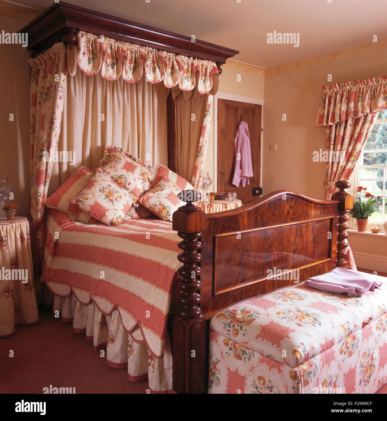 Arreglos florales en half tester cama antigua con melocotón+colcha con  rayas blancas en el país tradicional dormitorio Fotografía de stock - Alamy