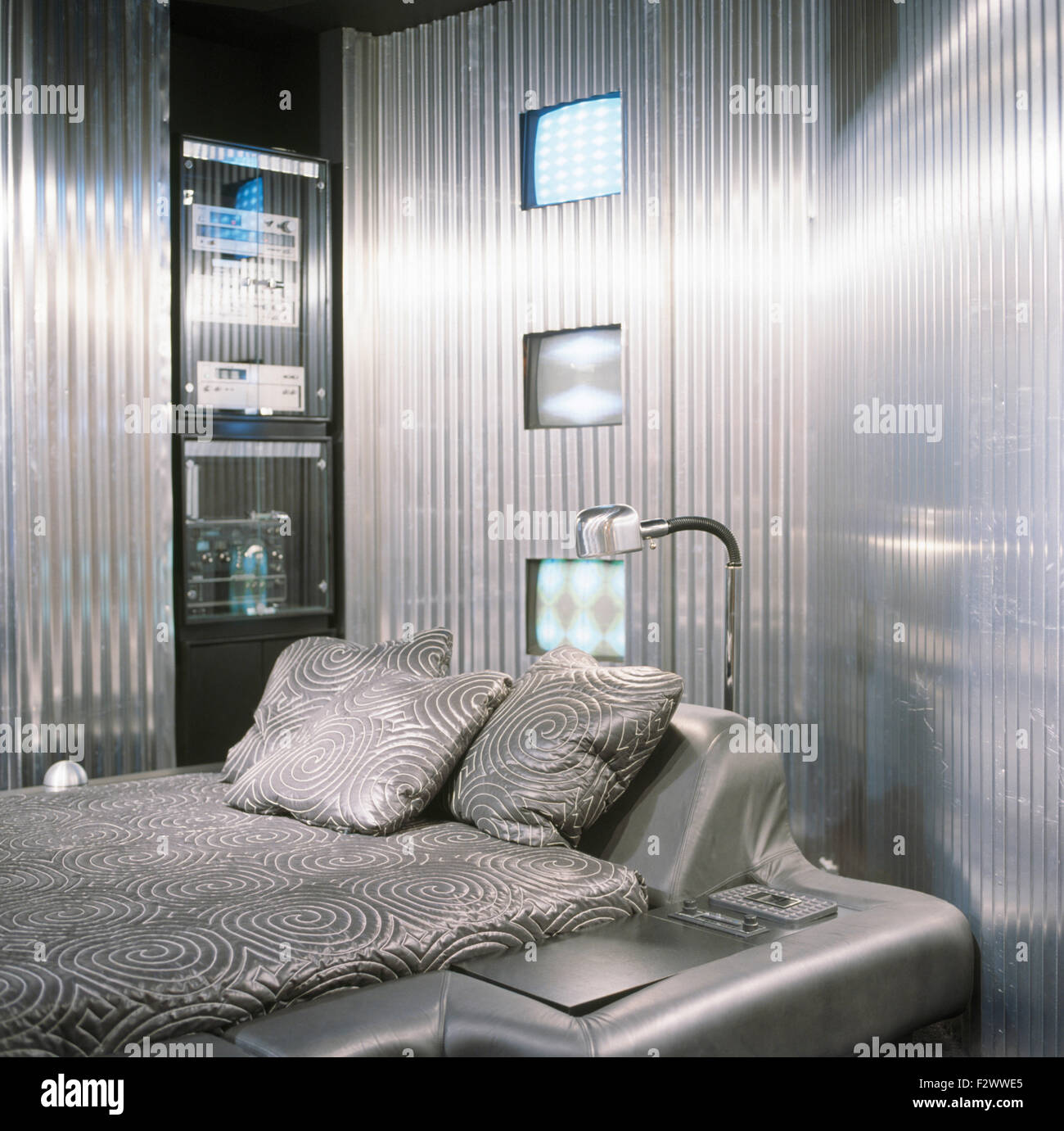 Paredes de metal corrugado en silver 80 dormitorio con una cama de cuero plateado equipado Foto de stock