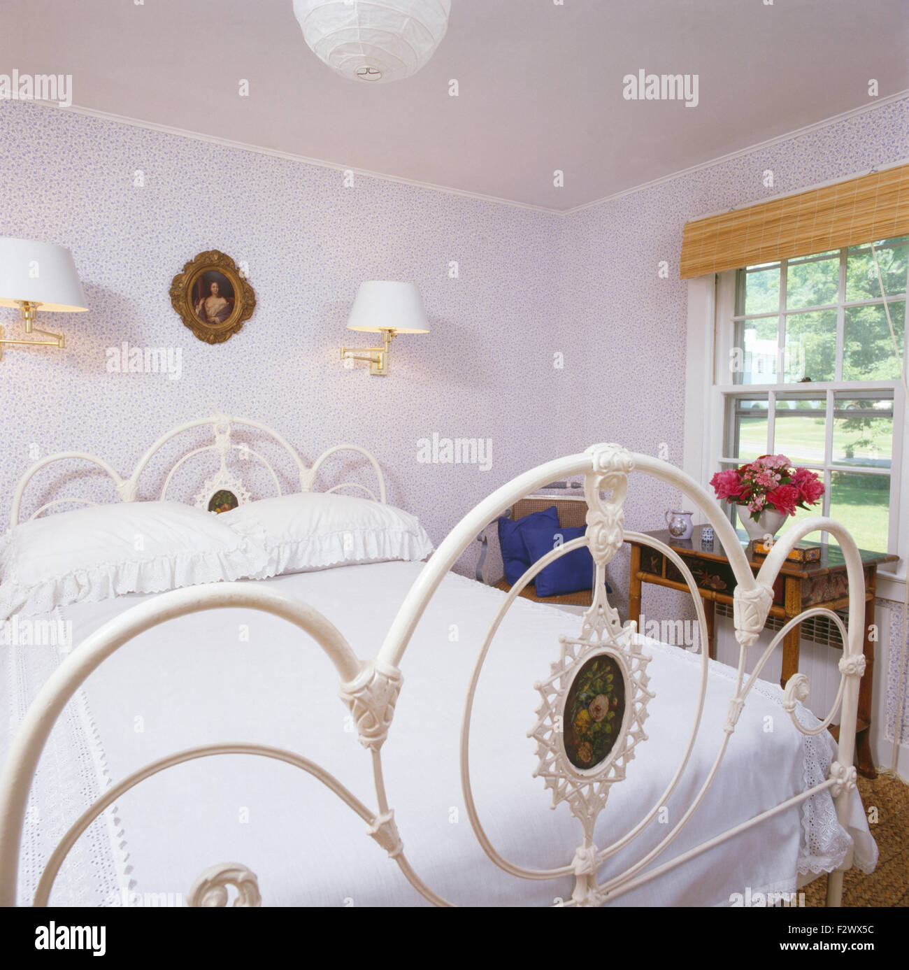 Blanco cama victoriana de hierro forjado con sábanas blancas en 90  dormitorio con empapelado azul Fotografía de stock - Alamy